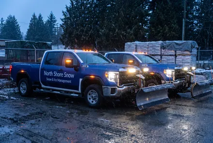 North Shore Snow trucks staged with plows mounted before a storm