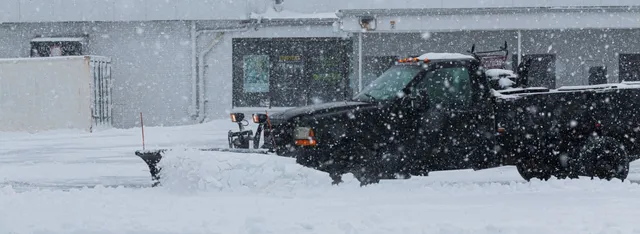 North Shore Snow plow truck clearing a commercial parking lot