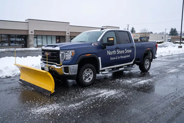 North Shore Snow plow truck on a commercial lot cleared and treated with ice melt